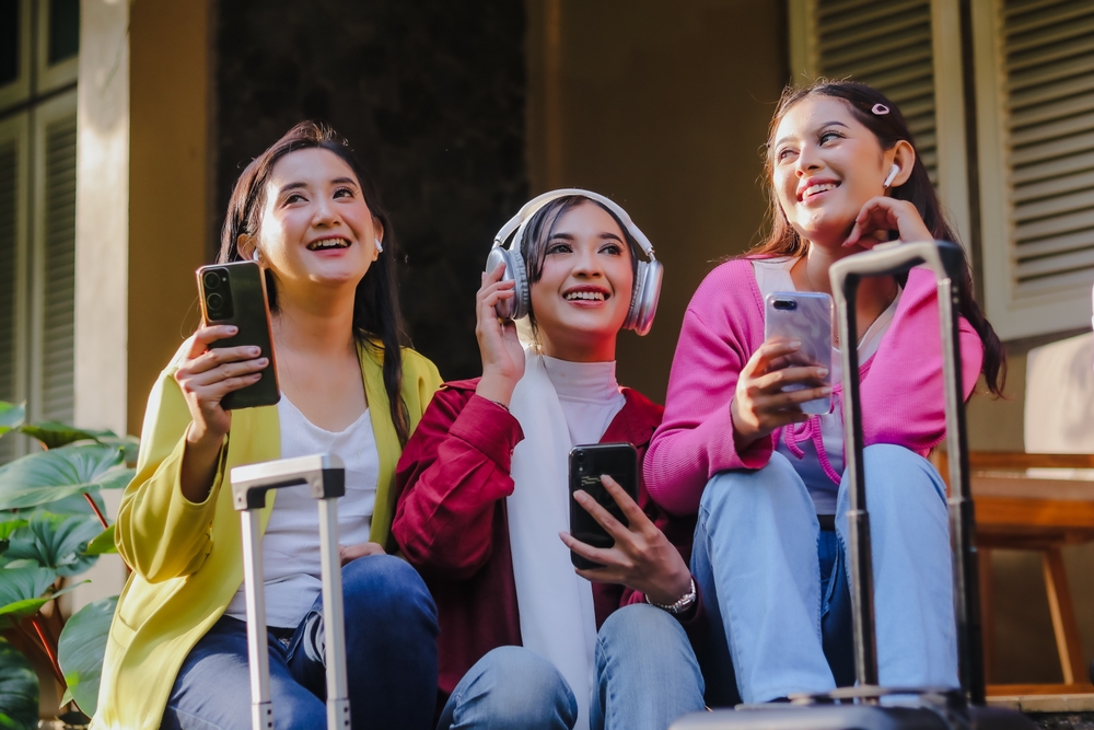 three,cheerful,young,women,,travel,companions,,eagerly,anticipate,their,adventure